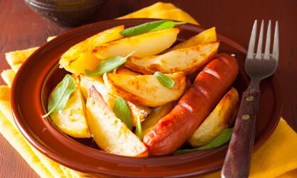 Currywurst mit Apfelcurrysoße, Kartoffel-Wedges und Salatbeilage